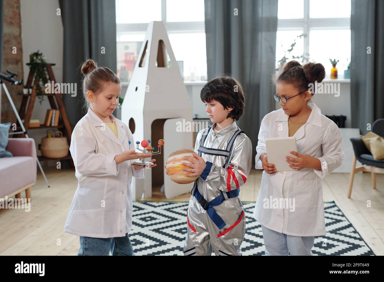 Group of children in costumes playing together in the room Stock Photo