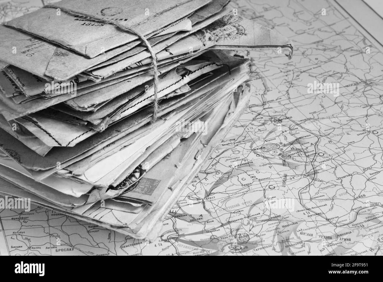 Sheaf of the paper letters on the military map of the World War II in Europe, 1944, black and white Stock Photo