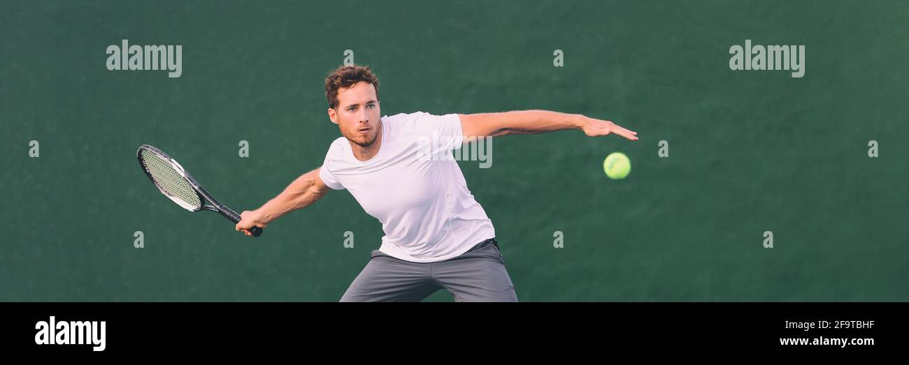 Tennis game man athlete hitting ball during match point on indoors tennis court at fitness health club. Panorama banner on green background Stock Photo