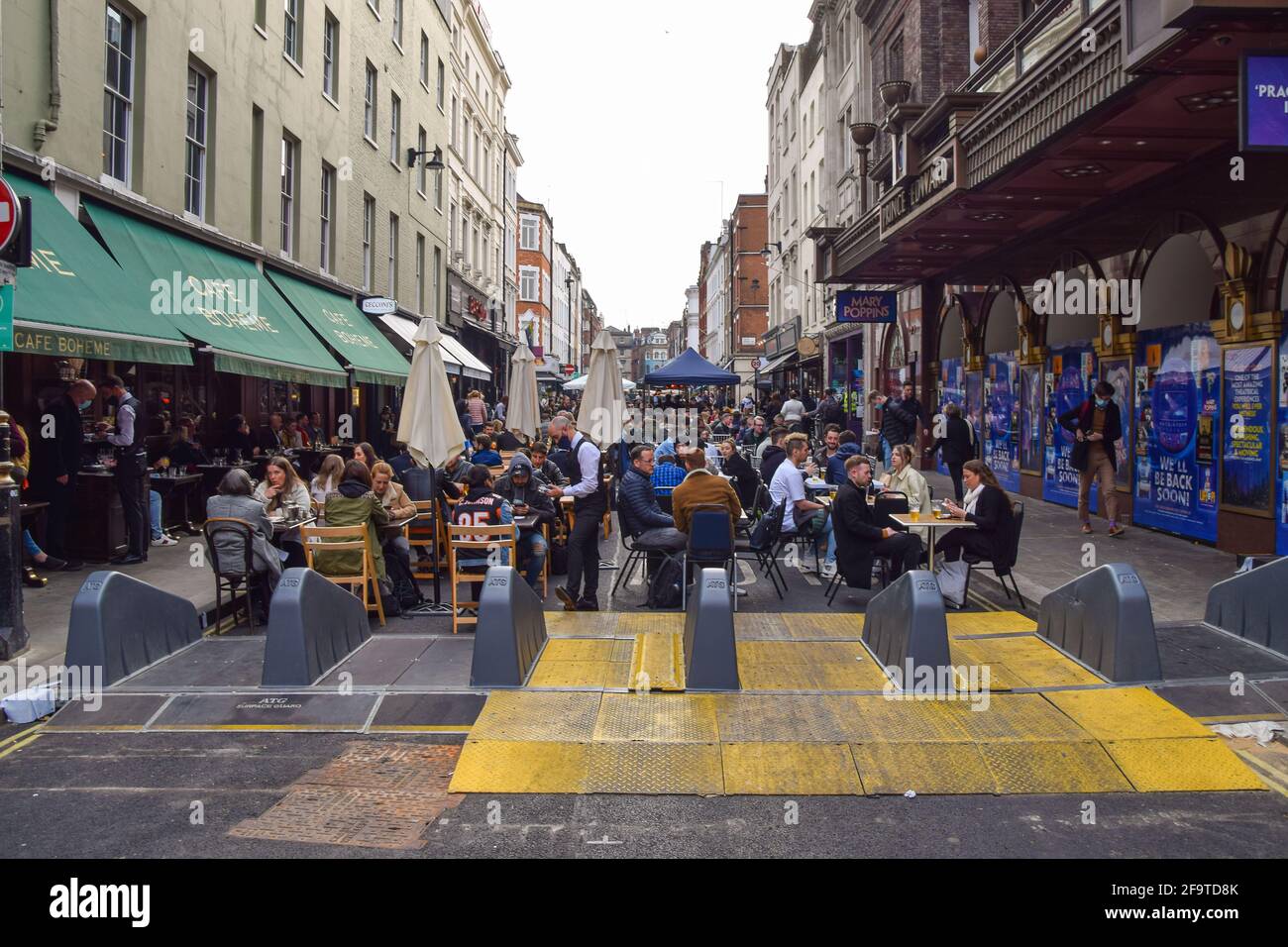 London, United Kingdom. 20th April 2021. Busy restaurants and bars in Old Compton Street. Several streets in Soho have been blocked for traffic to allow outdoor, al fresco seating at bars and restaurants. Stock Photo