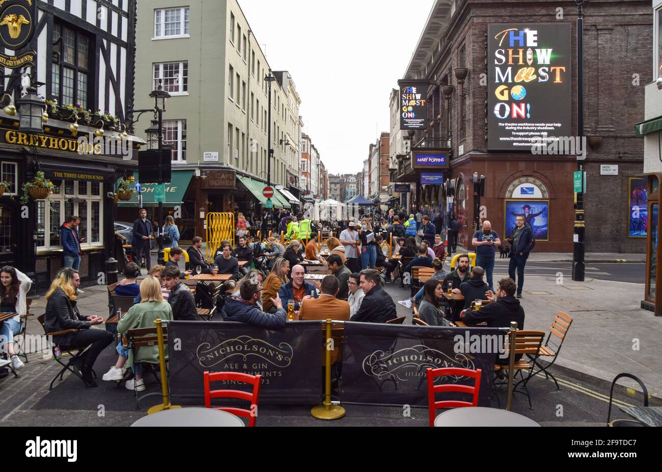 London, United Kingdom. 20th April 2021. Busy restaurants and bars in Old Compton Street. Several streets in Soho have been blocked for traffic to allow outdoor, al fresco seating at bars and restaurants. Stock Photo