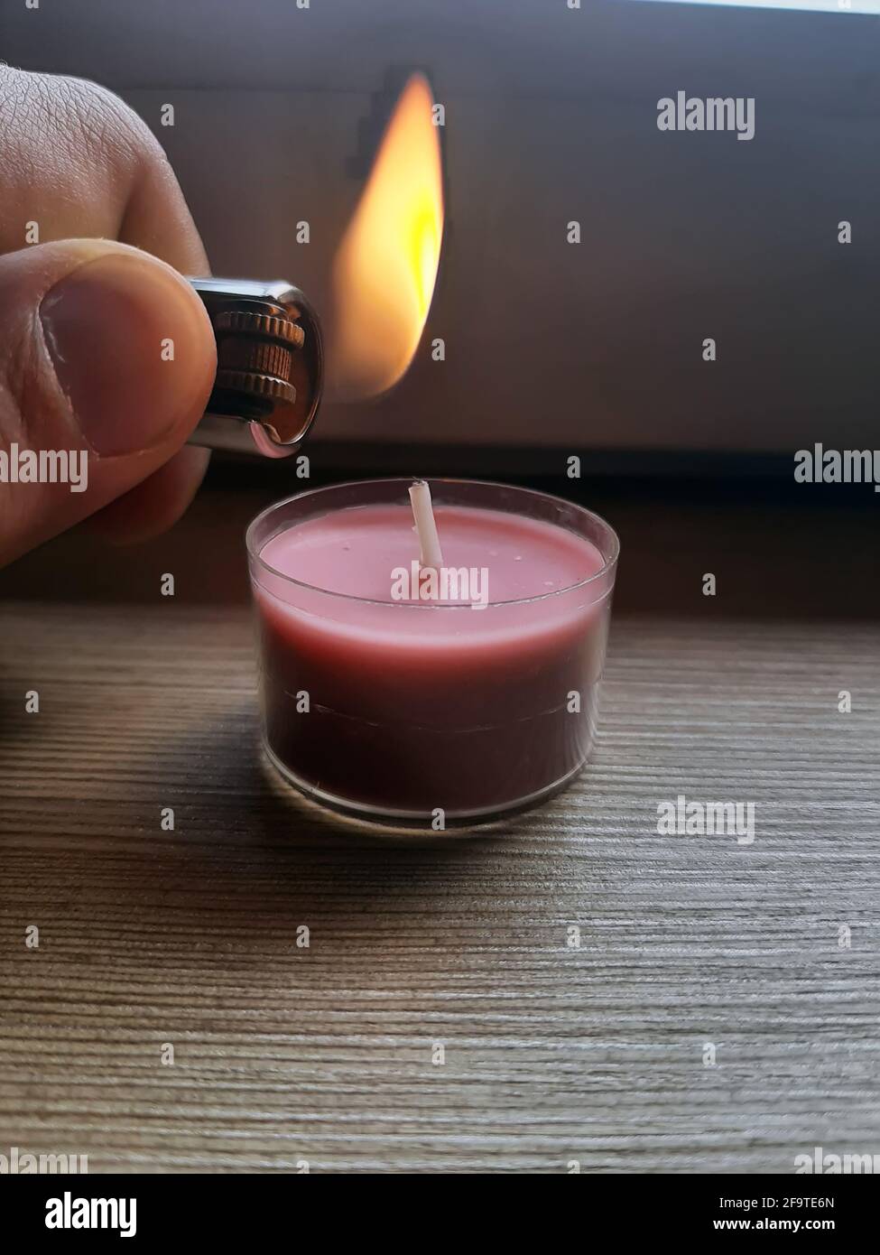 Lighting candle with a lighter. Hand holding lighter with flame Stock