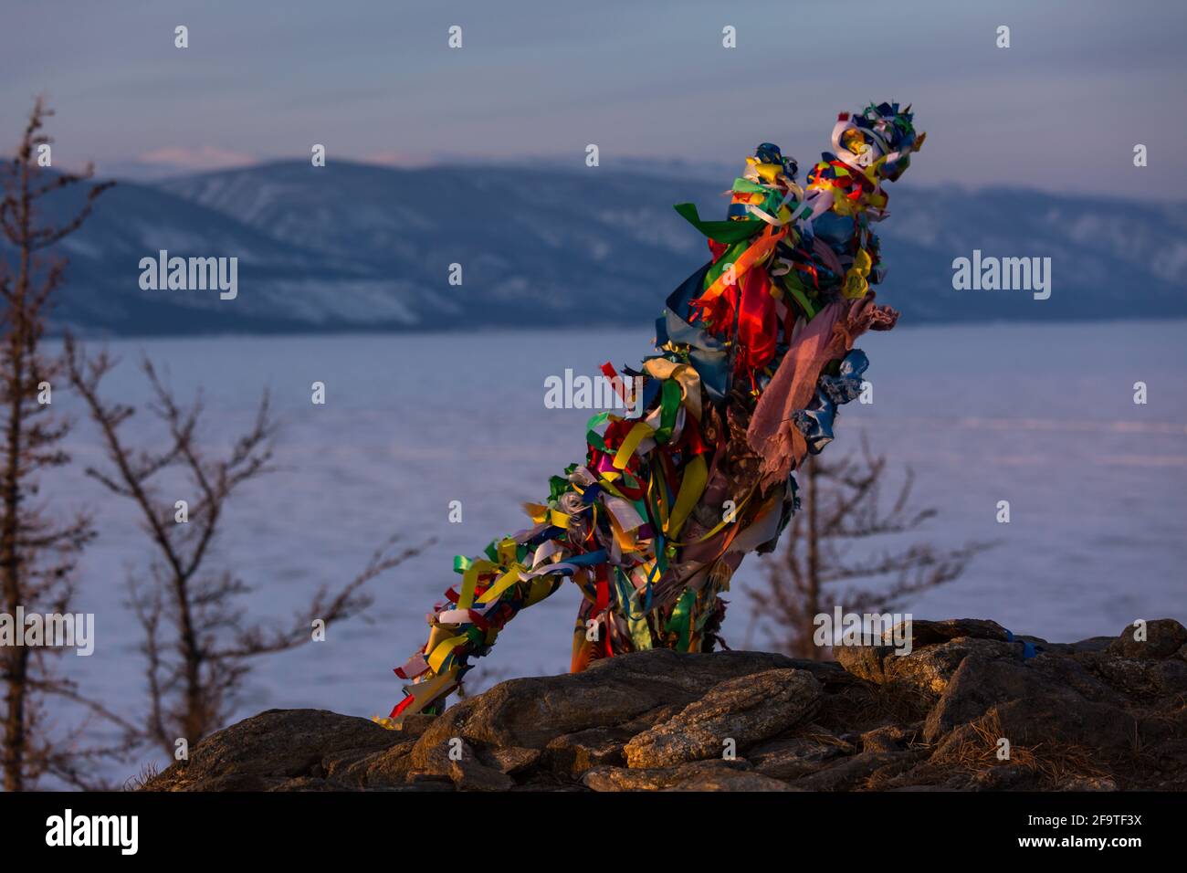 Colored ritual ribbons tied on the tree and wooden poles as a buddhist ...