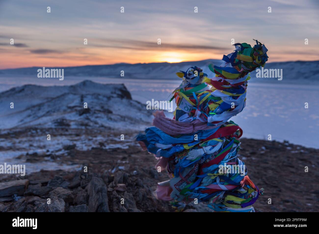 Colored ritual ribbons tied on the tree and wooden poles as a buddhist ...