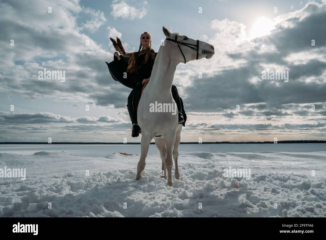 Young viking woman with red hairs ride a horse. Dramatic light. Role-playing game Stock Photo