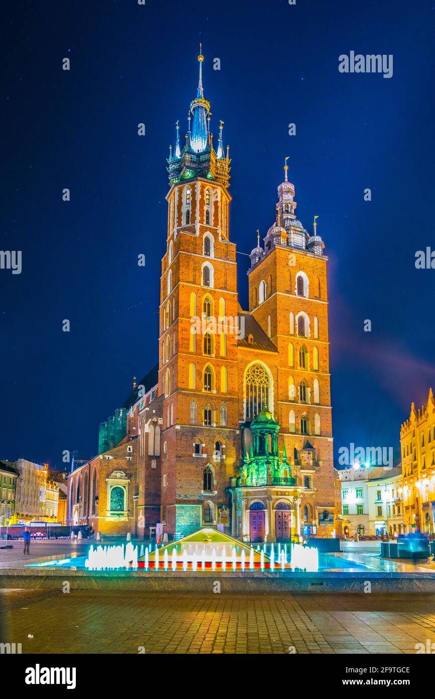 Night view of the church of Saint Mary with statue of adam mickiewicz on the rynek glowny main square in the polish city Cracow/Krakow. Stock Photo