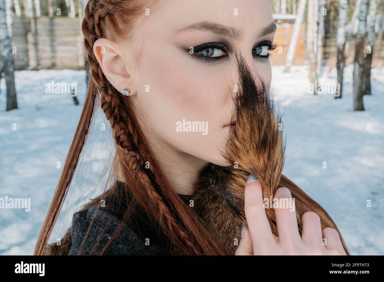 Young woman with red hairs and dreadlocks, dark smokey eyes make-up looking in the camera Stock Photo