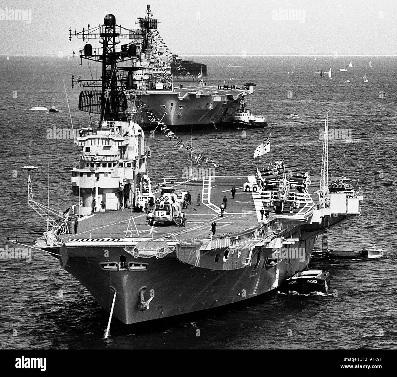 AJAXNETPHOTO. 28TH JUNE, 1977. SPITHEAD, PORTSMOUTH, ENGLAND. - LINE ASTERN - THE AIRCRAFT CARRIERS HMAS MELBOURNE AND HMS ARK ROYAL AT THE SILVER JUBILEE FLEET REVIEW.  PHOTO:JONATHAN EASTLAND/AJAX.  REF:EPS 120104 12 1 Stock Photo