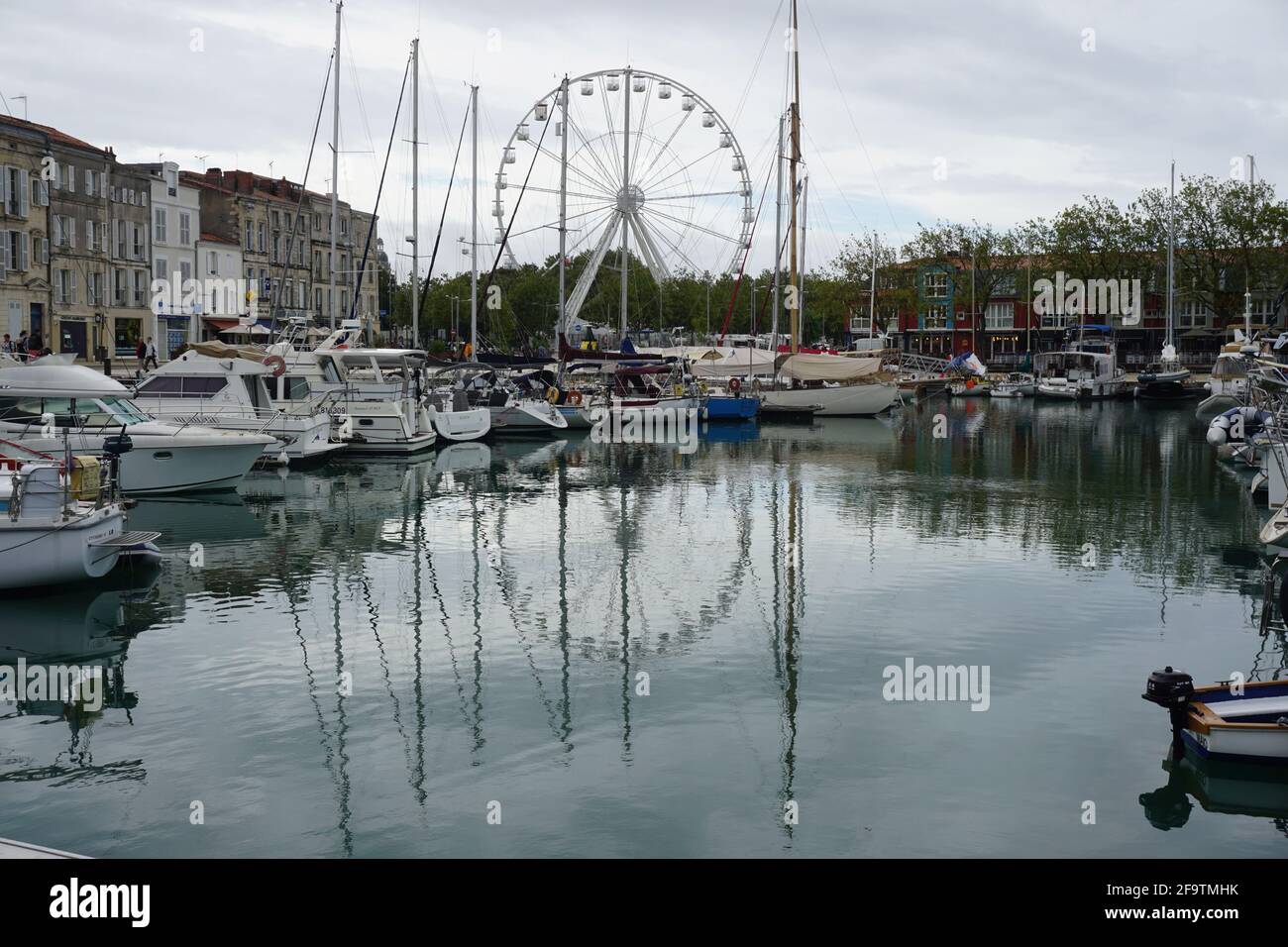 downtown La Rochelle, France by the harbor with the ferris wheel with mirror reflection in the water Stock Photo