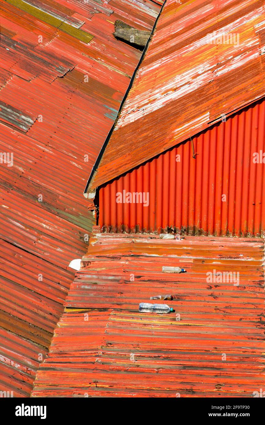 Weatherbeaten red corrugated tin roof above business premises Stock