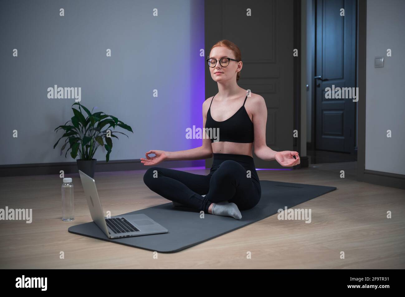 An experienced yoga coach conducts an online yoga class, the girl shows