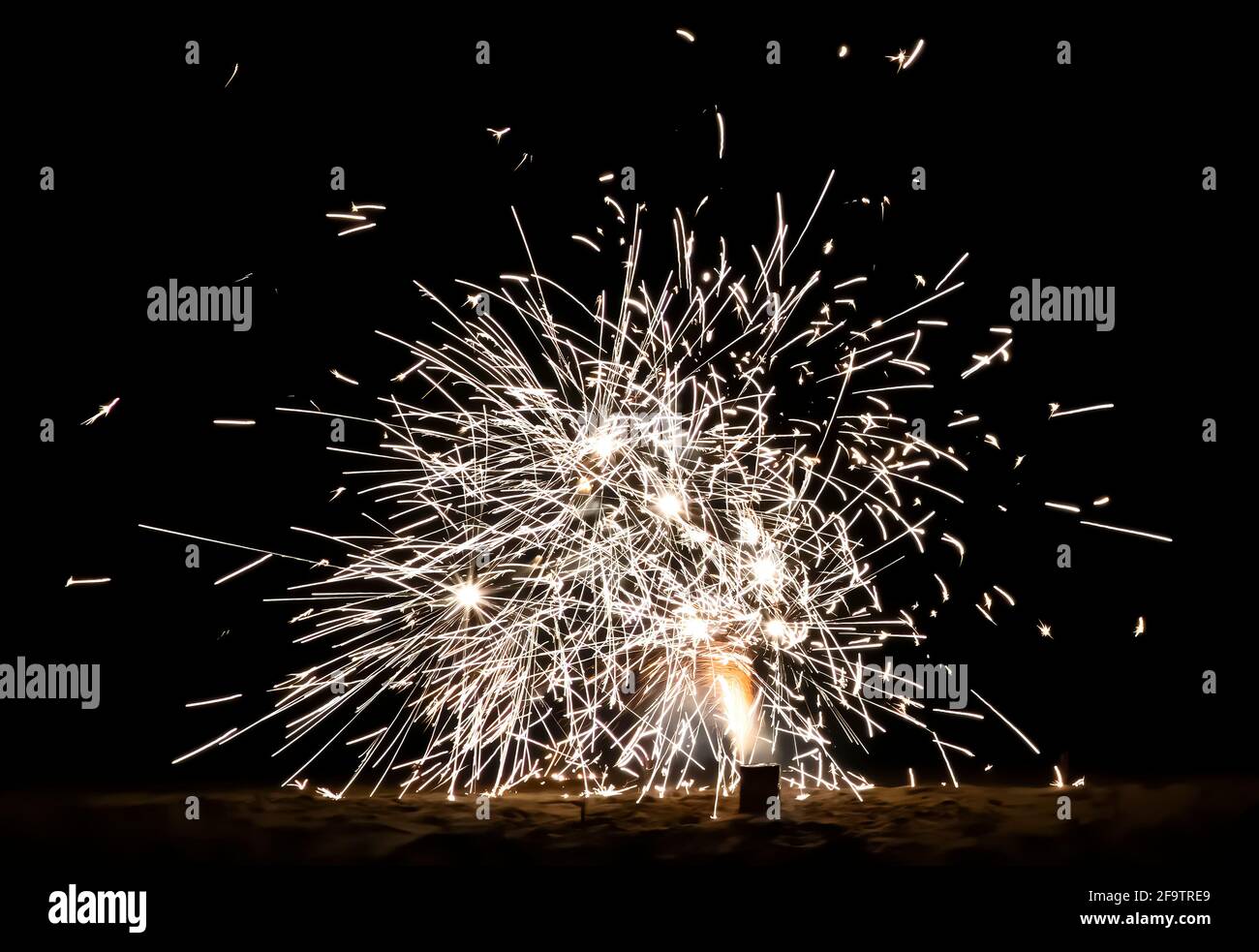 Close up fireworks on a beach at night with explosions of light on a black background. Stock Photo