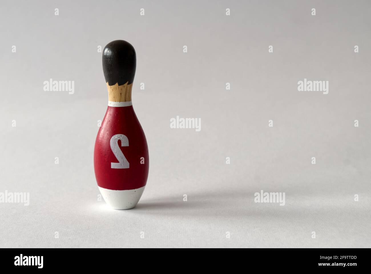 rearview of a wooden puppet in the shape of a bowling pin with a number two shirt Stock Photo