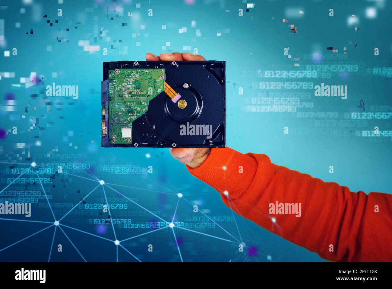 Man holds an hard disk. concept of storage and memory. cyan background Stock Photo