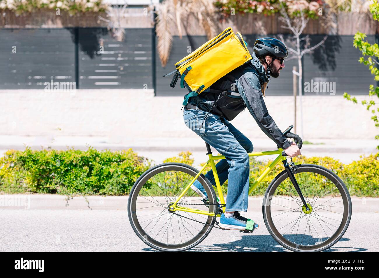 Man who works delivering food by courier at high speed through the city. Stock Photo