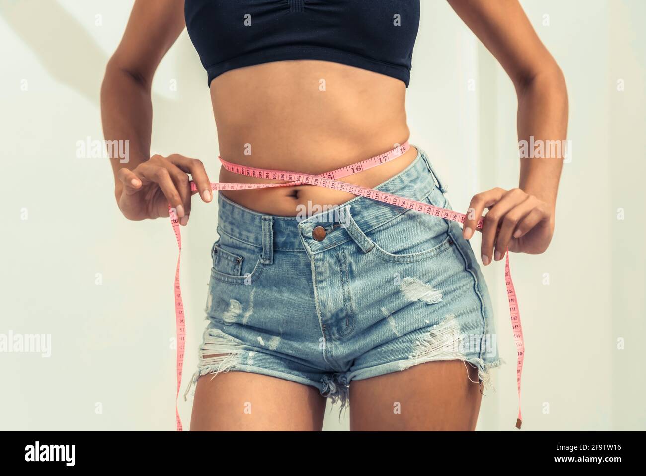 https://c8.alamy.com/comp/2F9TW16/young-slim-woman-measures-her-waist-by-measuring-tape-after-diet-against-white-backgrounds-concept-of-weight-loss-success-2F9TW16.jpg