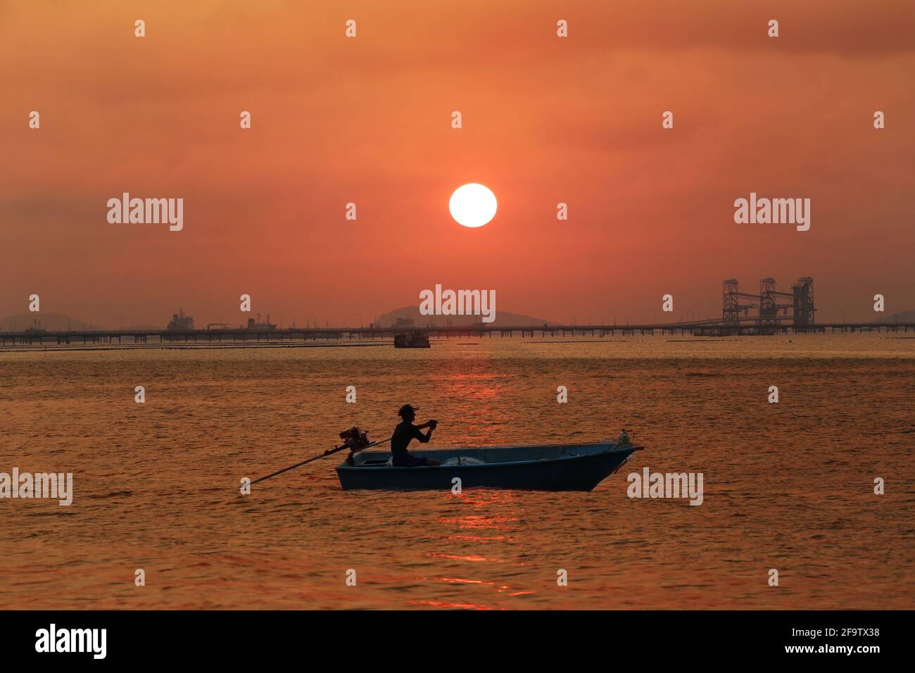A small boat running in the sea and sunset sky background. Stock Photo