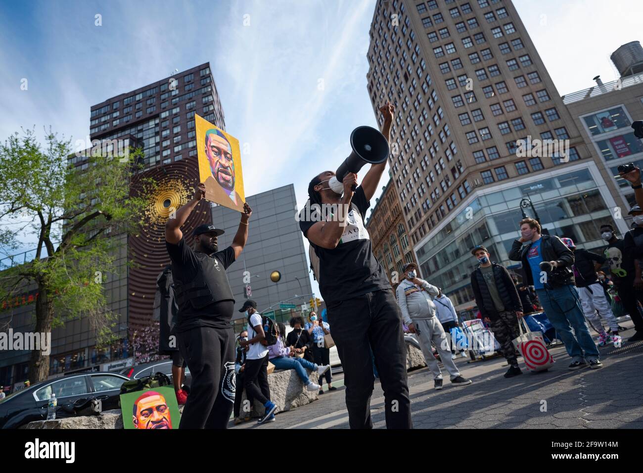 New York, New York, USA 20 April 2021.  Moments after former Minneapolis police officer Derek Chauvin was convicted of murdering George Floyd, defund police activist holds up portrait of Floyd while another speaks to crowd in New York's Union Square. Stock Photo