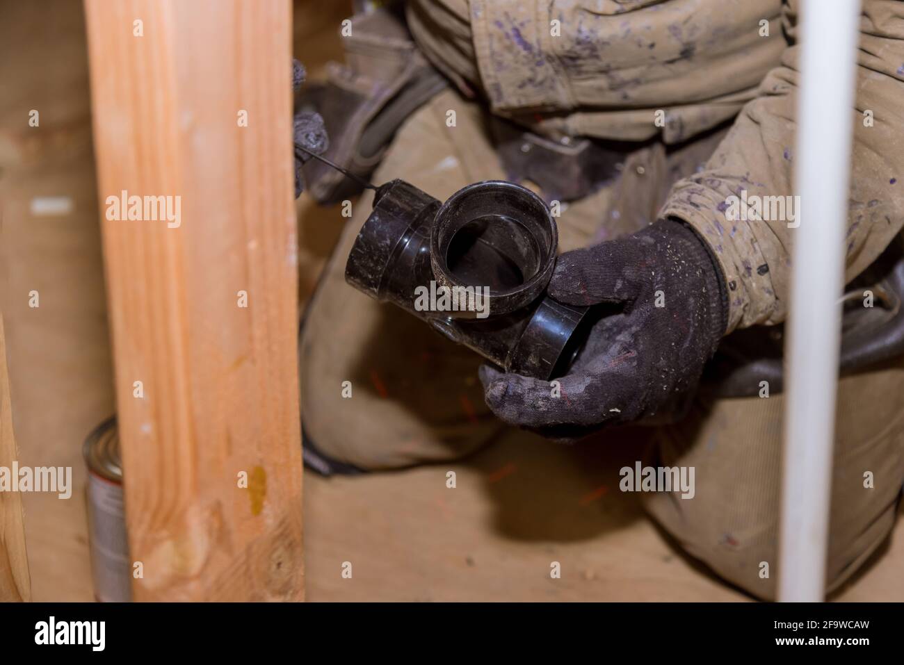 Plumbing contractor installing PVC plastic drain pipe in the section for custom house Stock Photo