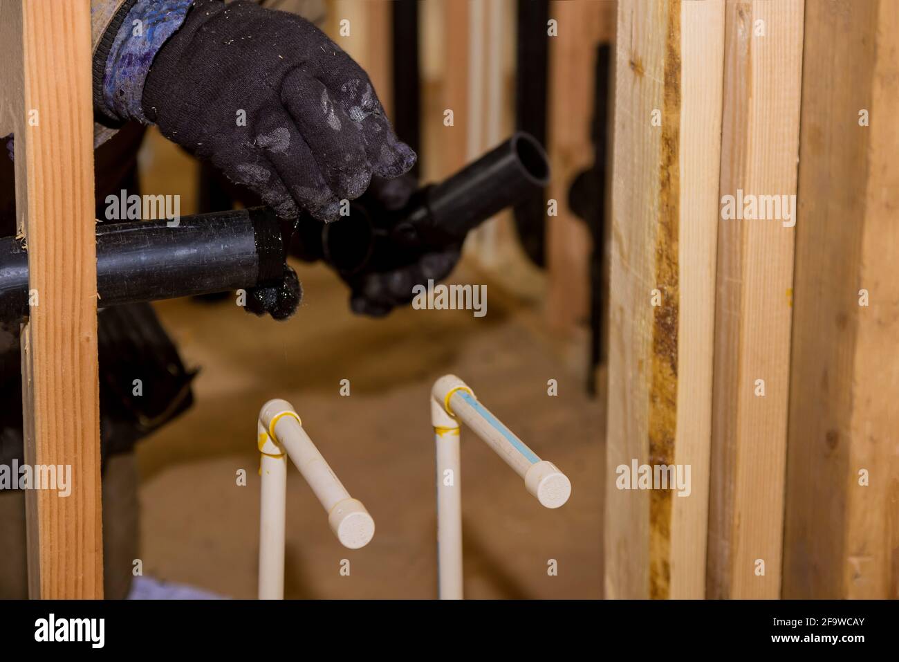 Plumbing building contractor installing plastic drain pipe in the elbow