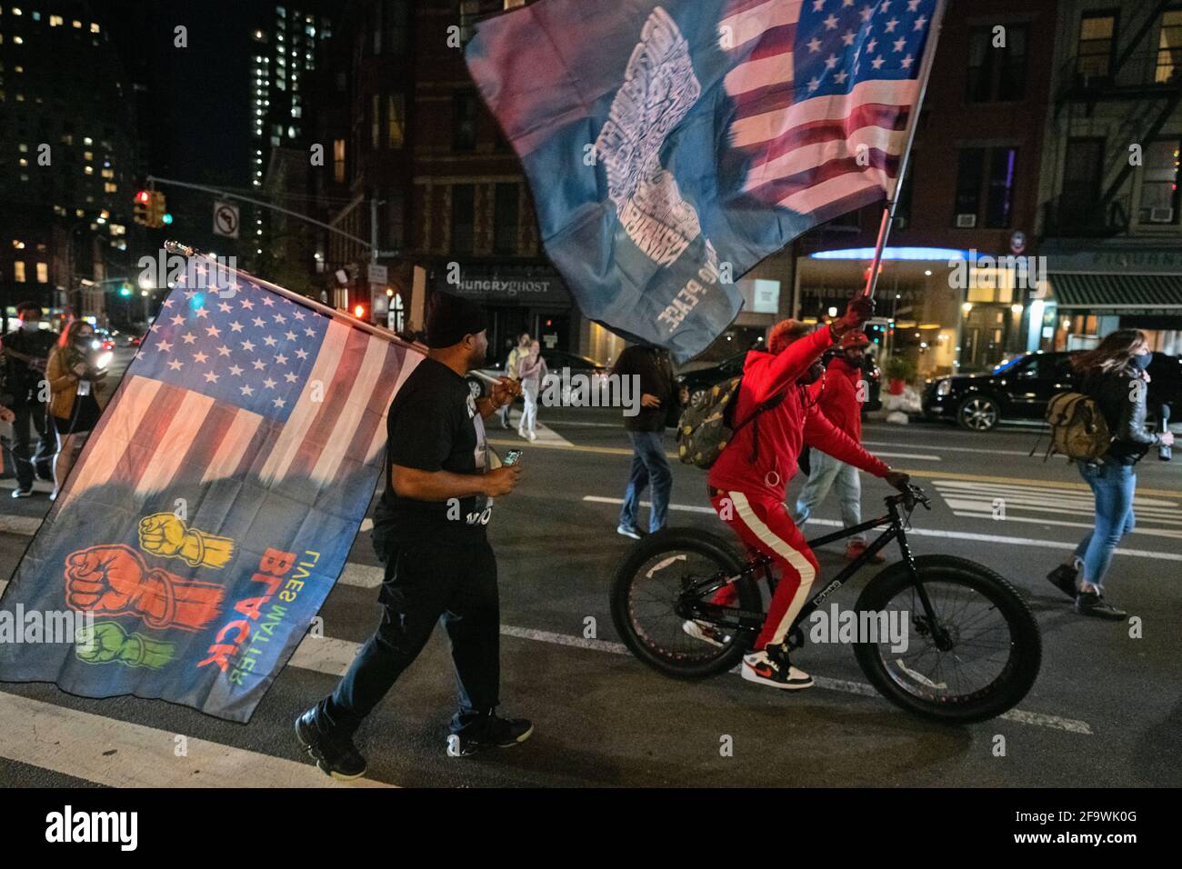 Brooklyn, New York, USA 20 Apr 2021. Protesters wave large Black Lives Matter flags during march through streets of Brooklyn hours after a jury found former Minneapolis police officer Derek Chauvin guilty of murdering George Floyd in 2020. Stock Photo