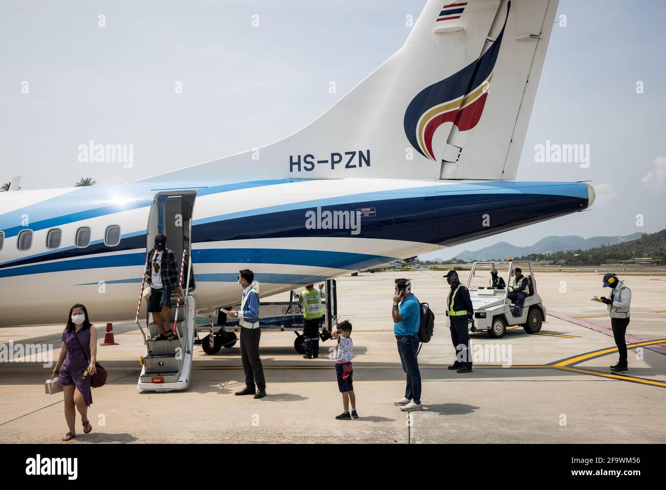 Passengers disembark a Bangkok Airways ATR 72-600 aircraft at Koh Samui airport Thailand on March 8, 2021 during the global covid-19 pandemic. Stock Photo