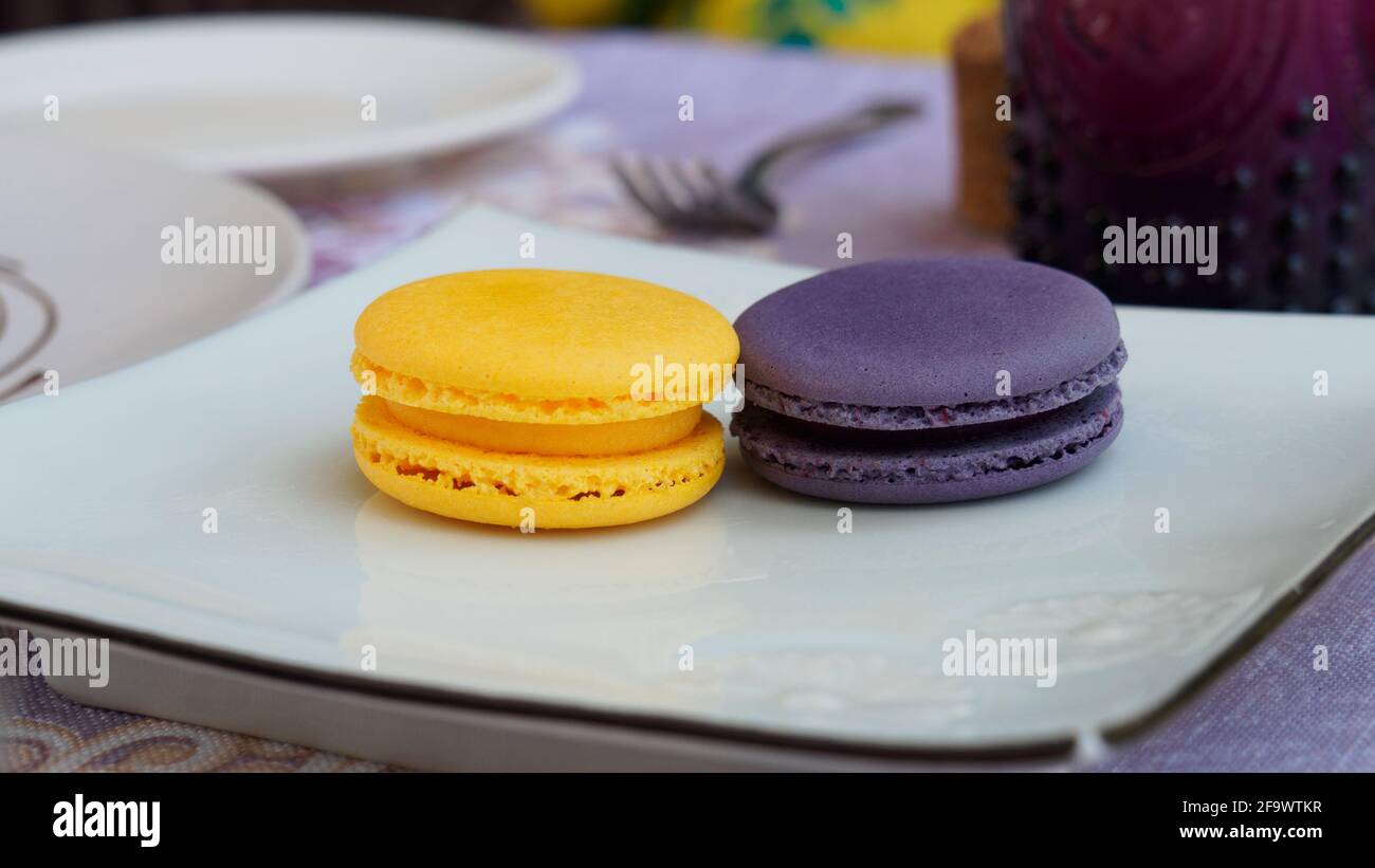 Yellow and violet Macaron or French Macaron, sweet confection introduced since 19th century. Stock Photo