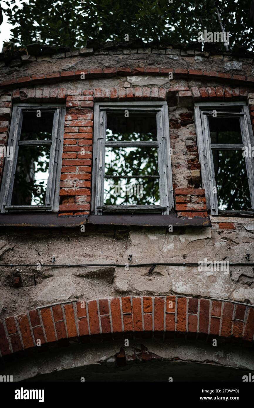 Low angle shot of a semi-destroyed facade of an old brick building on a ...