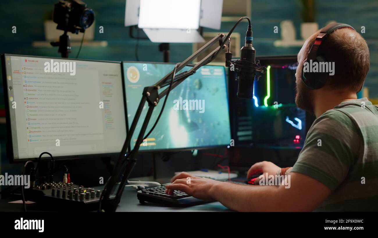 Man gamer teaching his girlfriend playing space shooter video game on RGB  powerful personal computer. Pro cyber woman with headset performing video  games streaming from home during online tournament Stock Photo 