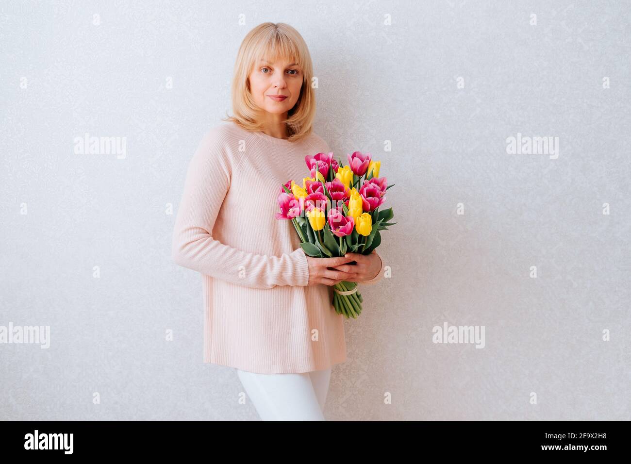Beautiful mature woman holding tulips. Stock Photo