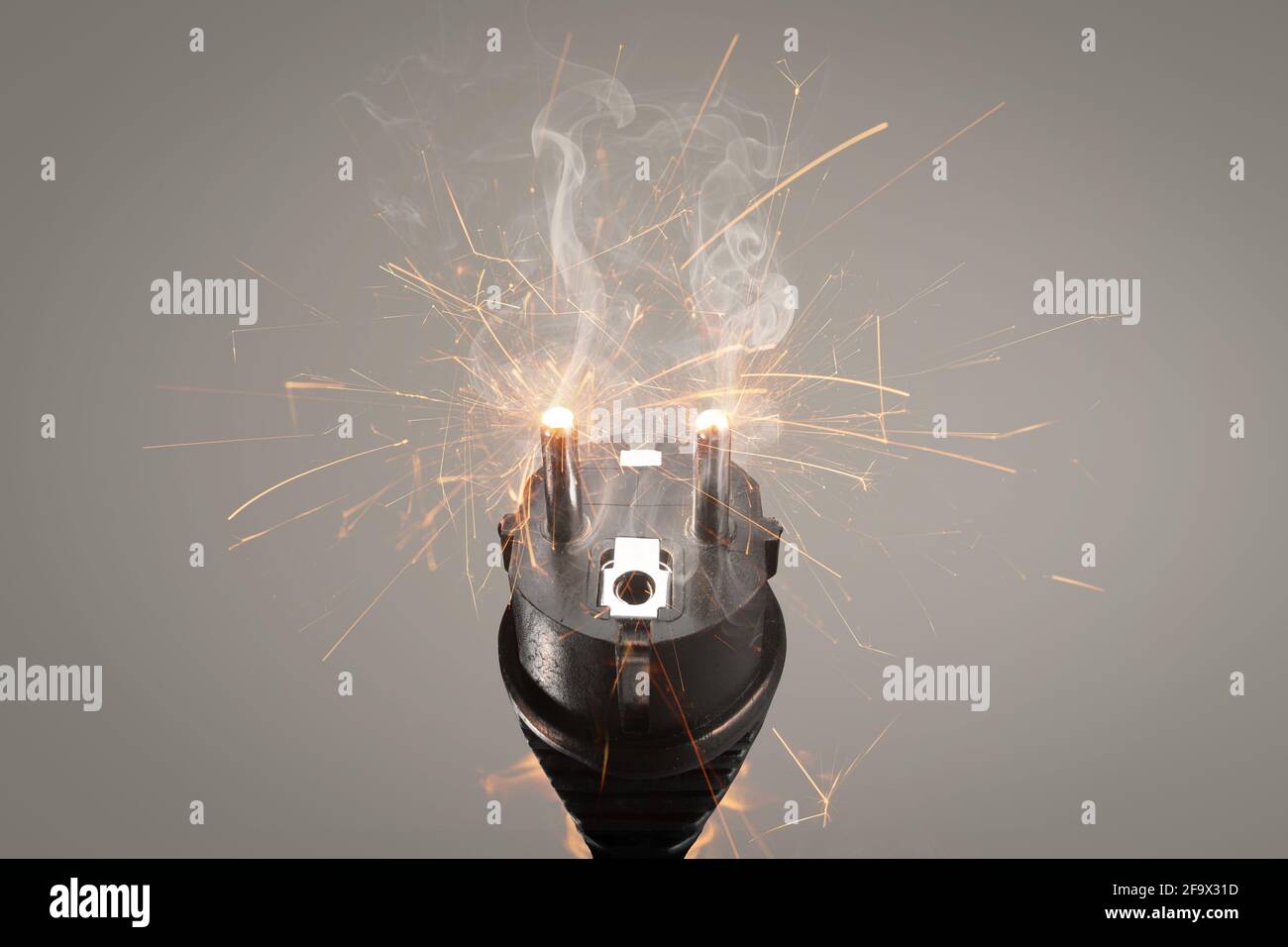 Faulty power plug with flying sparks and smoke Stock Photo