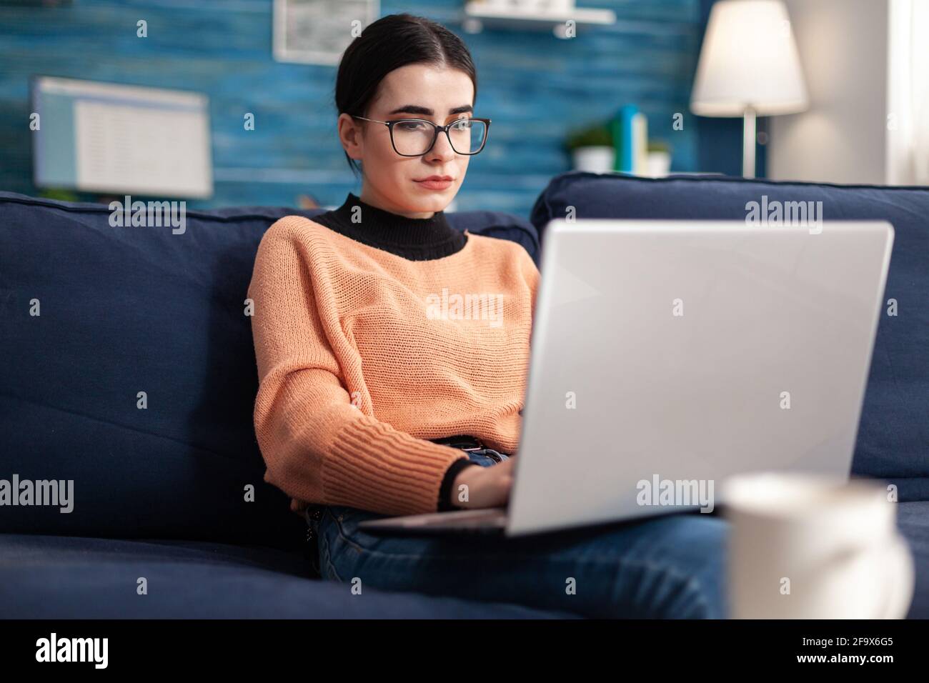 College student with glasses checking email on laptop computer while ...