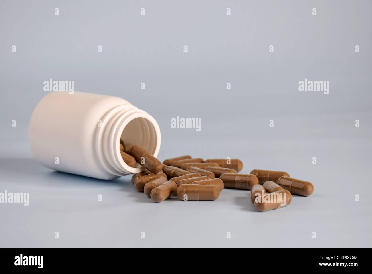 Natural brown capsules with pressed medicinal herb,pills in open