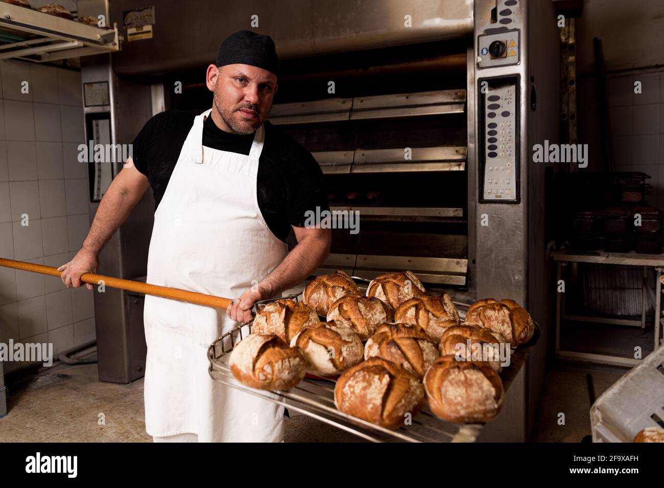 professional bread baker in bakery shop and posing with shelf with uncooked  raw bread knead on shovel. concept of traditional manual bread preparation  Stock Photo - Alamy