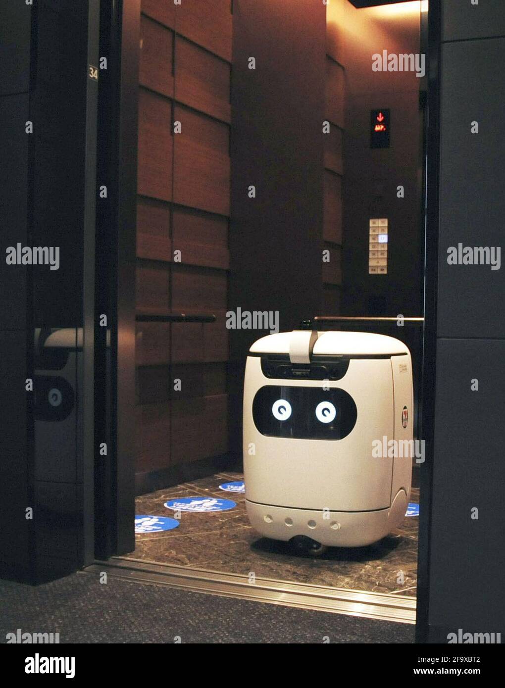 A delivery robot rides in an elevator in Tokyo on April 20, 2021. Convenience store chain operator Seven-Eleven Japan Co. and wireless carrier SoftBank Corp. announced the same day they will jointly conduct a full test of the robot in which it will carry food and beverages from a Seven-Eleven convenience store inside a building where Softbank is headquartered to office rooms in the building from the following day to the end of June. (Kyodo)==Kyodo  Photo via Newscom Stock Photo