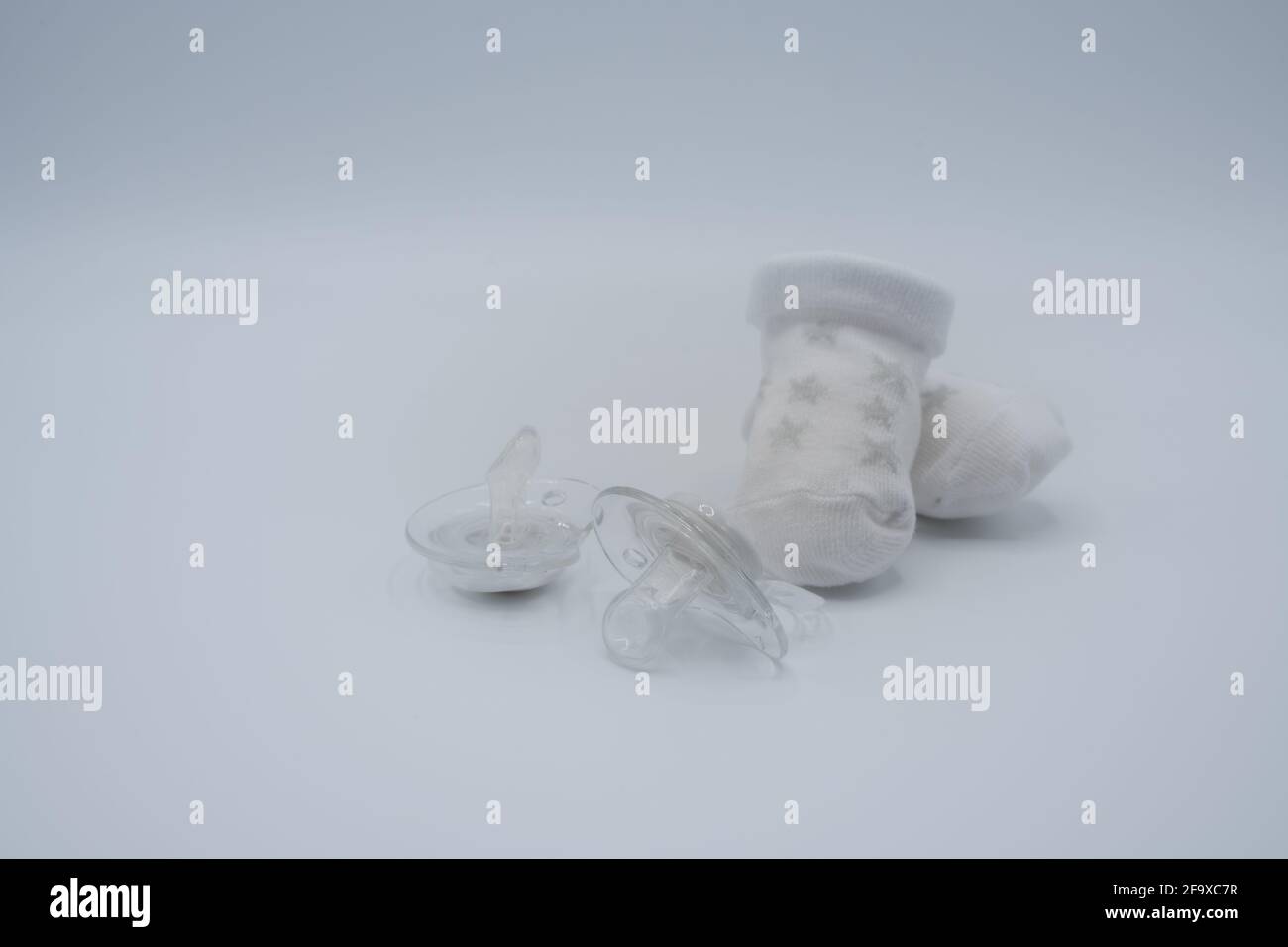 Newborn composition with booties and dummies Stock Photo