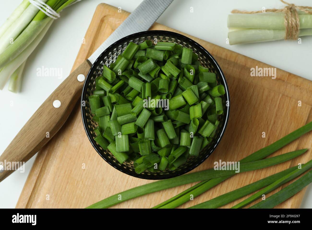 Fresh green onion on cutting board on white background Stock Photo - Alamy