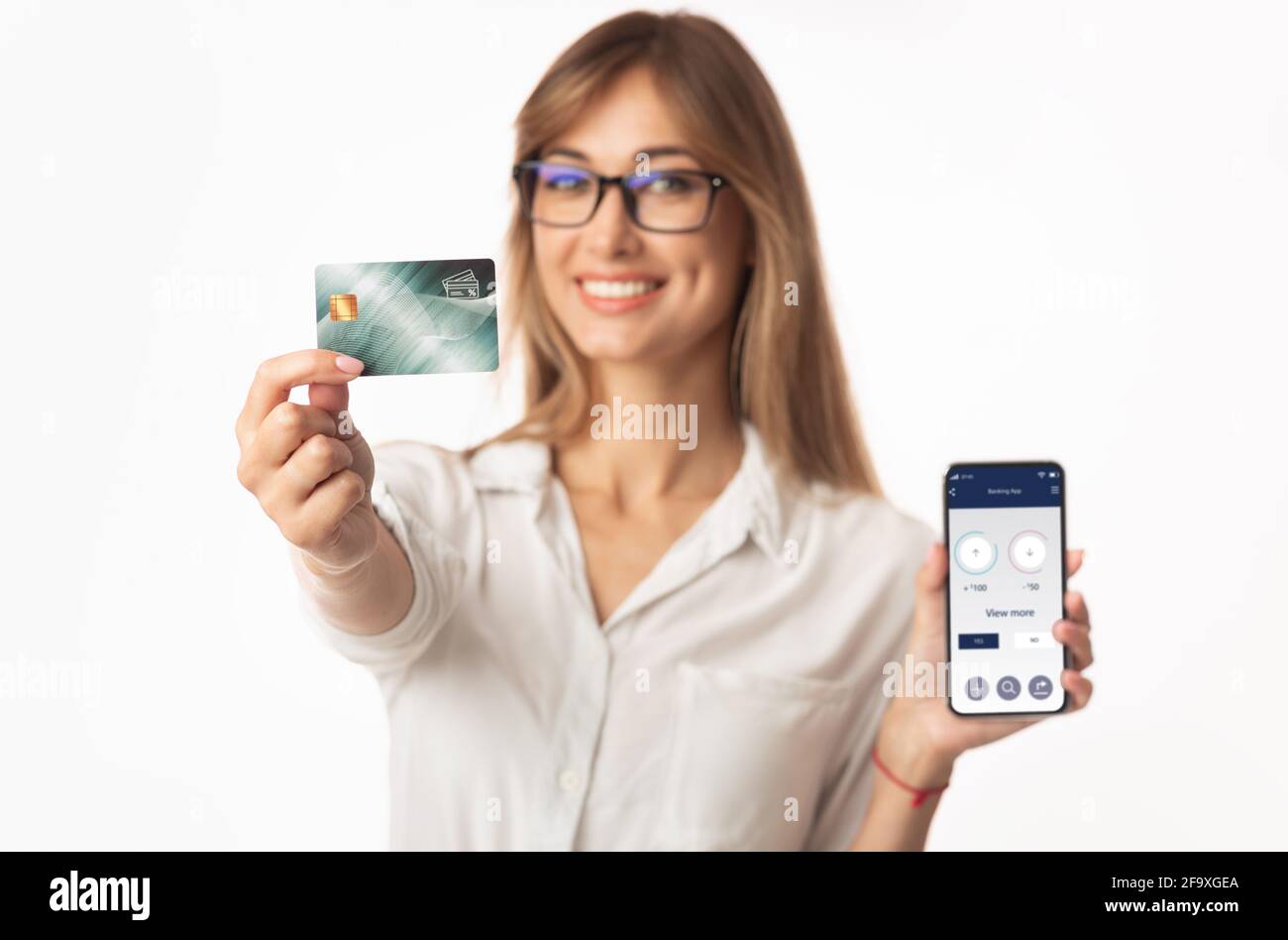 Pretty young woman showing credit card and banking app Stock Photo