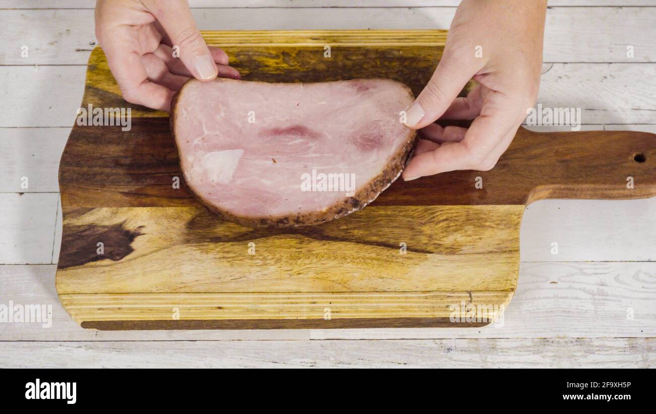 Cutting organic honey ham on a wood cutting board Stock Photo - Alamy
