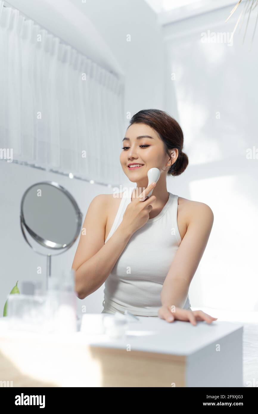 beutiful asian woman doing skin treatment her self at home. galvanic facial Stock Photo