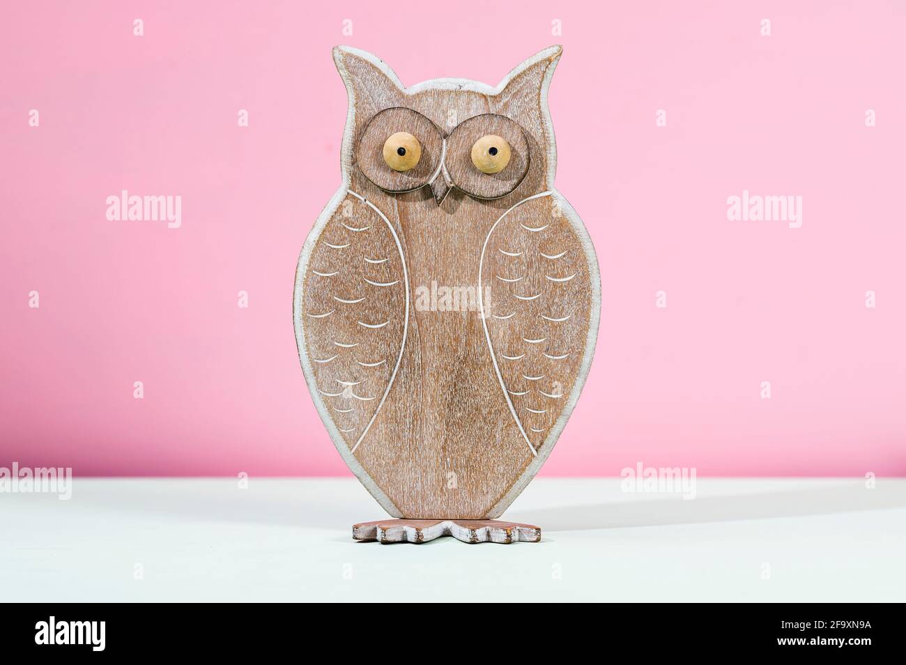 A wooden owl on a coloured background Stock Photo