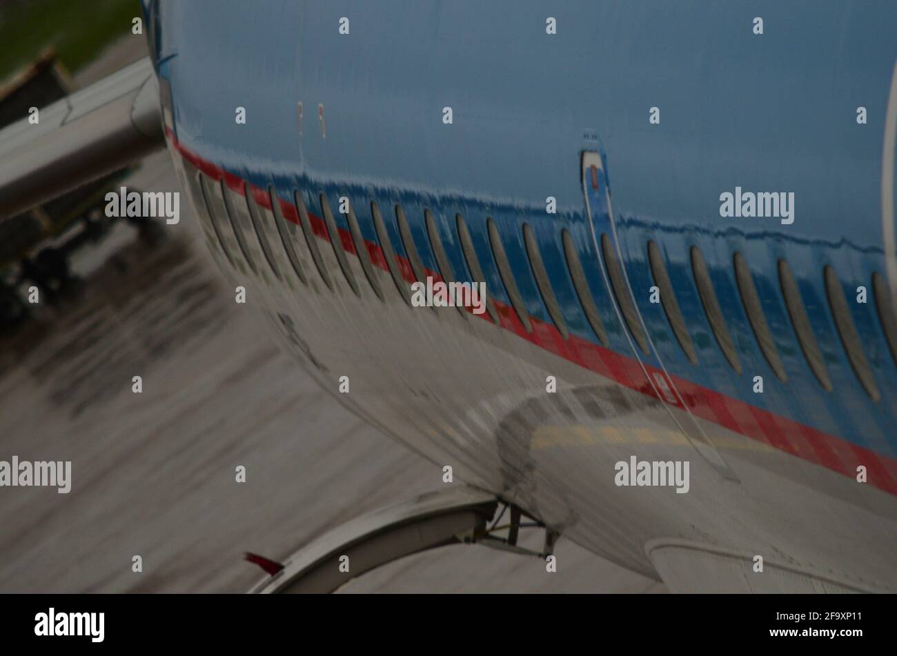 Airplane queue with open luggage door in airport on rainy day Stock Photo