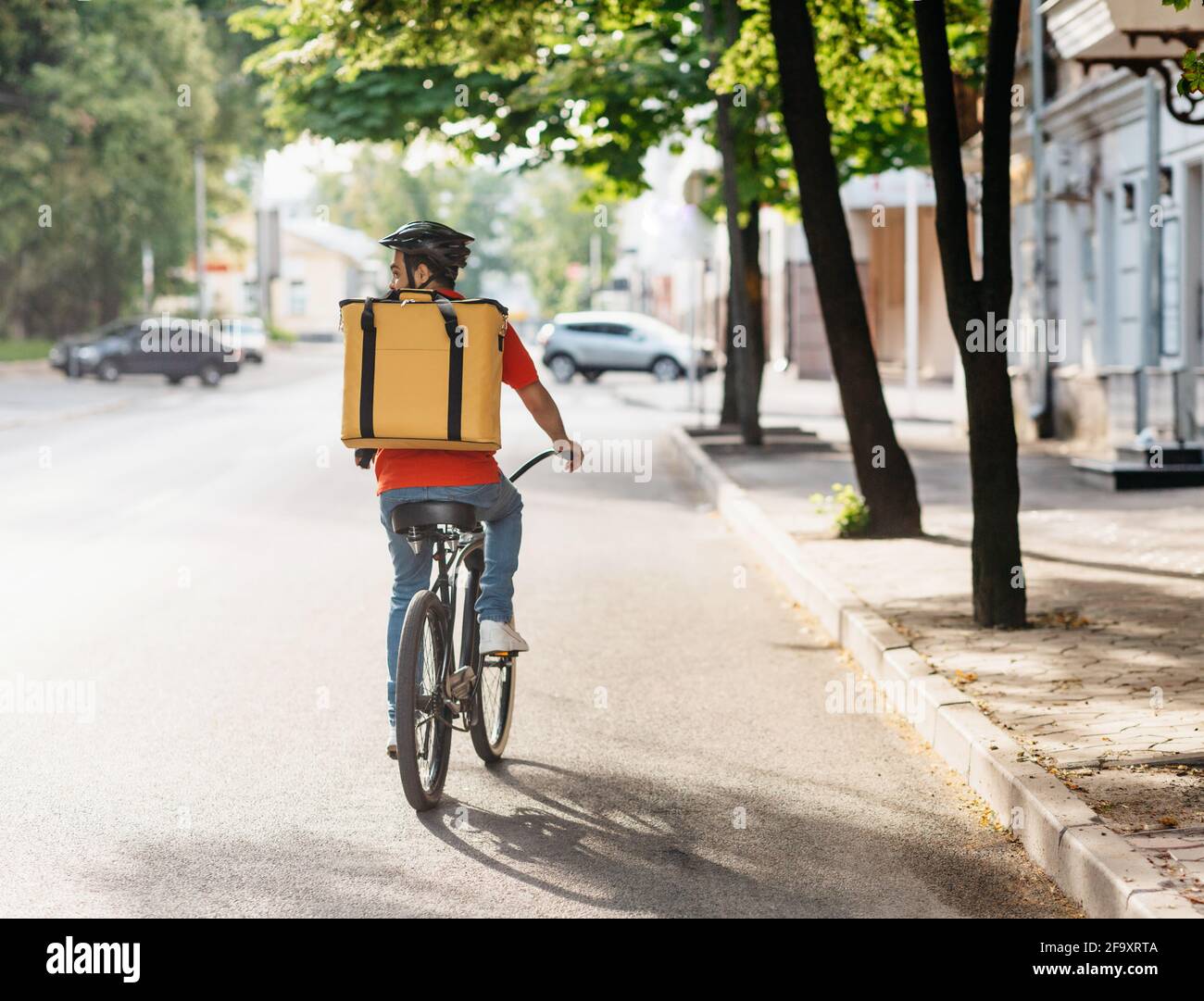 Courier on bicycle with parcel, bike delivery service Stock Photo