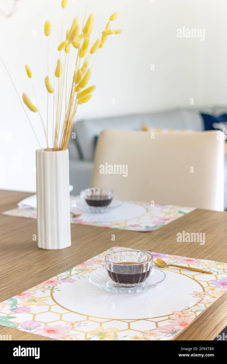 Coffee time. Table decorated with button plant and long vase Stock Photo