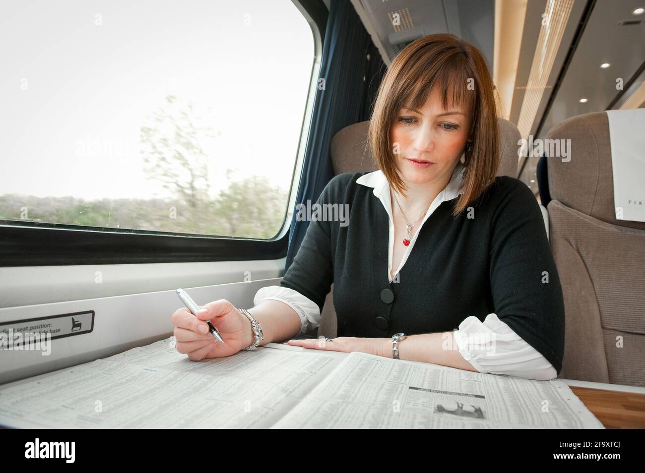 Young woman travelling on a train in the UK. Stock Photo