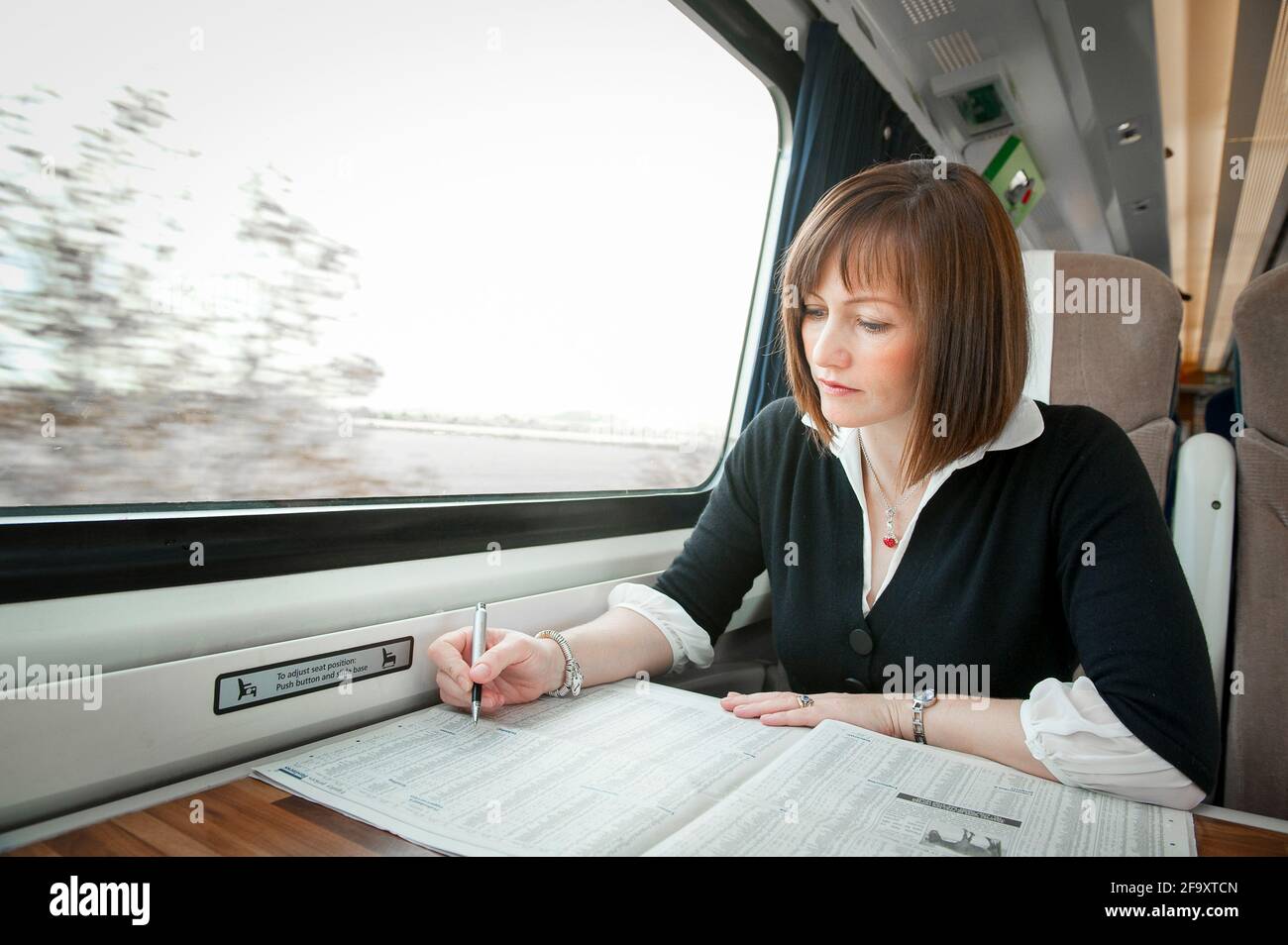 Young woman travelling on a train in the UK. Stock Photo