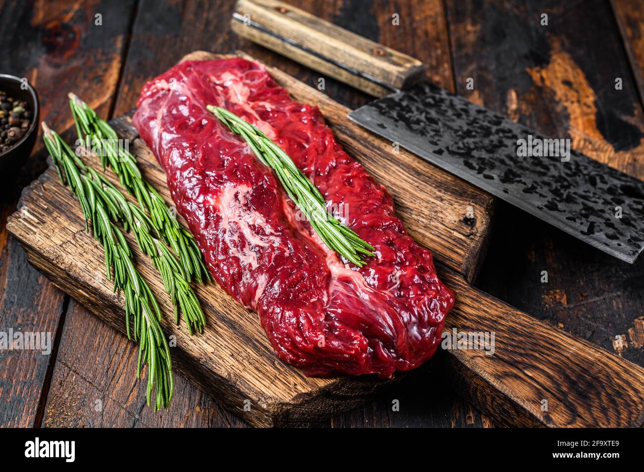 Butchers choice raw steak Onglet Hanging Tender beef meat on a cutting board. Dark wooden background. Top view Stock Photo