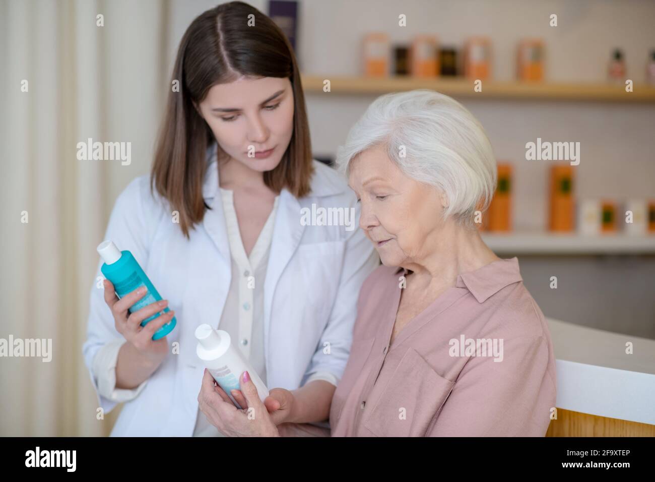 Pretty young cosmetologist talking a to a mature customer Stock Photo