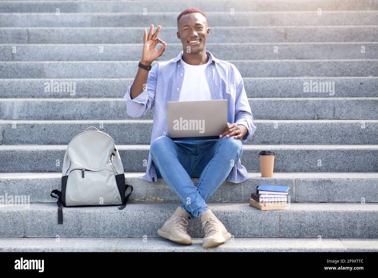 Online education. African American student with laptop, backpack and ...