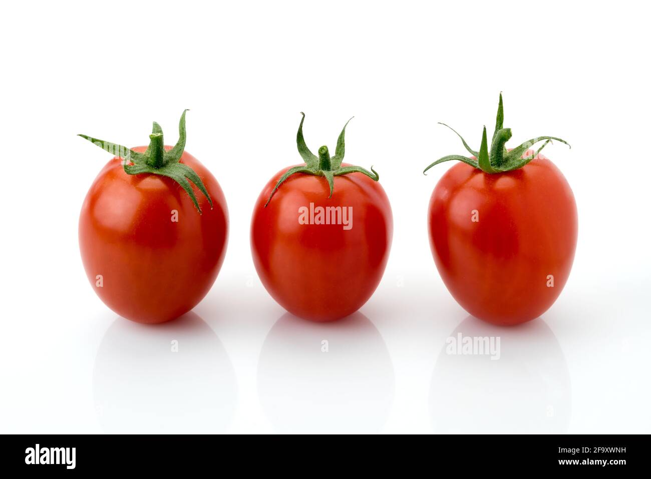 three red cherry tomato , datterino type isolated on white, copy space Stock Photo